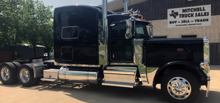 Black commercial truck sitting in lot in front of Mitchell Truck Sales LLC